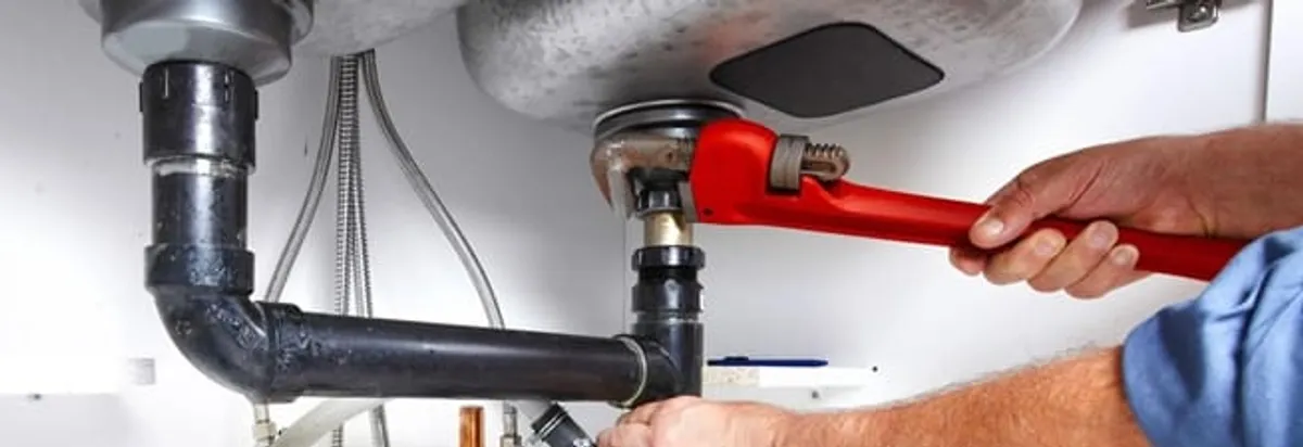 Garbage disposal repair technician tightening the sink drain and disposal connection in Marietta, GA